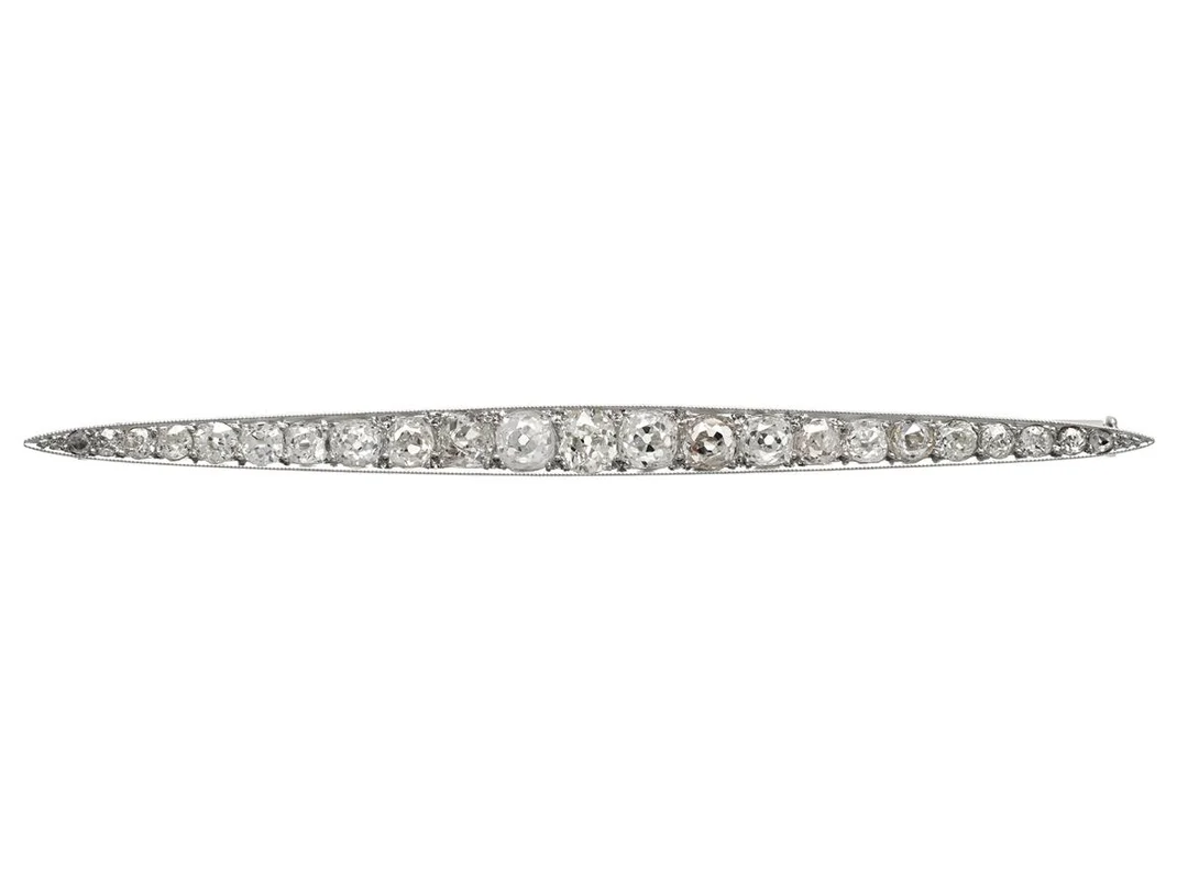 BROSCH, platina med nål i 18K vitguld, antikslipade diamanter ca 2,00 ctv, Frankrike, tidigt 1900-tal, svenska importstämplar, längd 78 mm, vikt 6,0 g, några diamanter har skador och nagg, etui, kvitto från försäljning i Stockholm 1934. — Smycken/Brosch — Kaplans