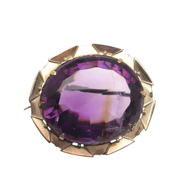 AN AMETHYST AND GOLD BROOCH.