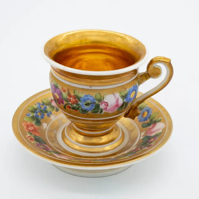PORZELLAN TASSE MIT UNTERTELLER, ANFANG 19. JAHRHUNDERT FRANZÖSISCH EMPIRE, KARTUSCHE MIT MONOGRAMM, HANDBEMALT, MIT BLUMENDEKOR.