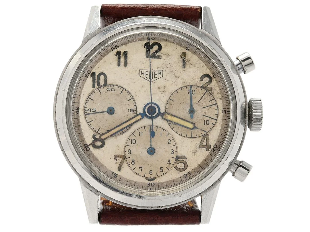HEUER, kronograf, Cal Valjoux 72, Serie nr. 451414, Ref nr. 2447, Boett nr. 71939, herrur, 38 mm, stål, manuell, plexiglas, relumade visare, OBS: skadad boett (sprickor, se bilder), läderband, ca 1944. — Klockor/Heuer — Kaplans