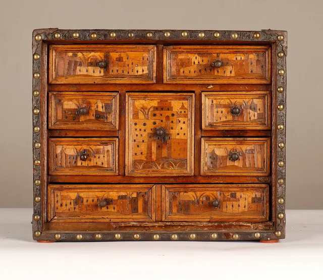 Pequeño cabinet de sobremesa alemán forrado en piel, con frente en marquetería pictórica de Augsburgo, hacia 1600.