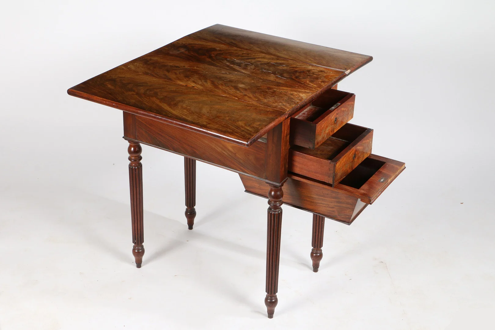 IN THE MANNER OF GILLOWS OF LANCASTER A GEORGE III FLAME MAHOGANY WORK TABLE. — Tables — Bishop & Miller