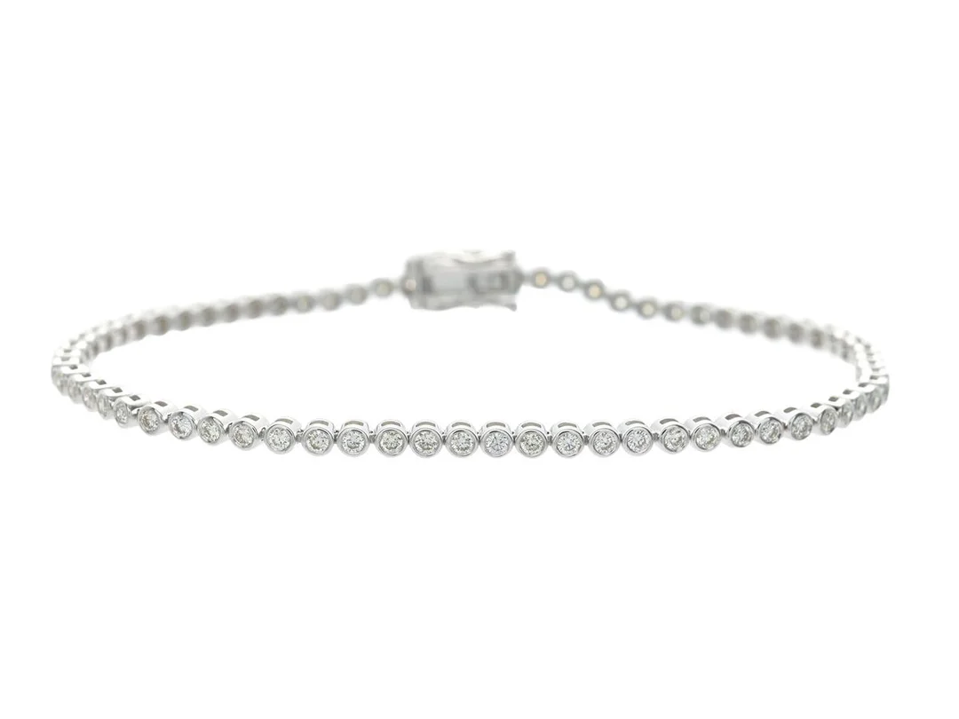 TENNISARMBAND, 18K vitguld, 69 briljantslipade diamanter ca 1,28 ctv, ca TW-Cr/VVS-VS, längd 17,5 cm, vikt 6,9 g. — Smycken/Tennisarmband — Kaplans
