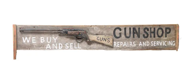 A FOLK ART STYLE WOODEN GUN SHOP SIGN.