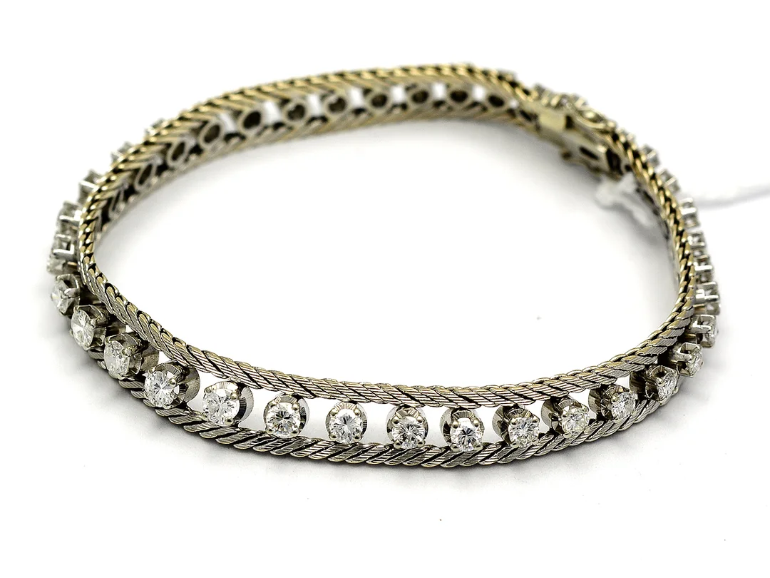 Armband i vitguld med diamanter 3xca0,02ct 7xca0,04ct, 5xca0,05ct 4xca0,06ct 1xca0,07ct, 5xca0,08ct, 5xca0,10ct, 3xca0,11ct, 2xca0,12ct 1xca0,14ct (två diamanter skadade) 18K 18,4g 17,5cm — Smycken/Armband — Kaplans