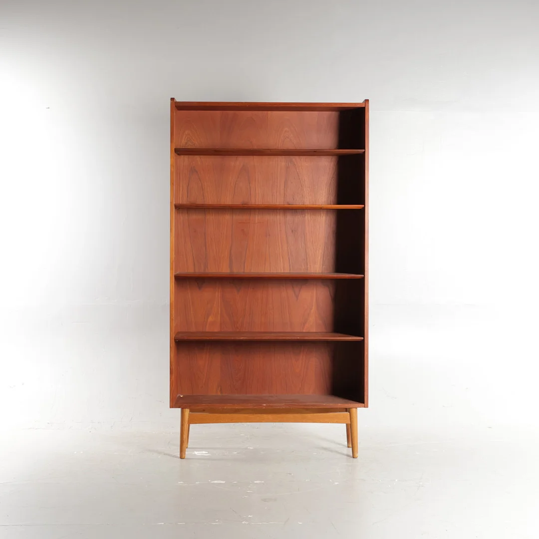 JOHANNES SORTH. “Bornholmerreolen”, reol af teak, front med justérbare hylder, massiv stel af eg. Udført hos Bornholms Møbelfabrik, Nexø. Danmark, 1950-60'erne. — Cupboards, Cabinets & Shelves — Woxholt Auktioner