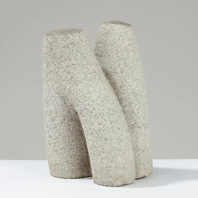 Organisk skulptur af grålig granit med polerede toppe, antageligt udført af dansk billedhugger og signeret med initialerne 'KA'.