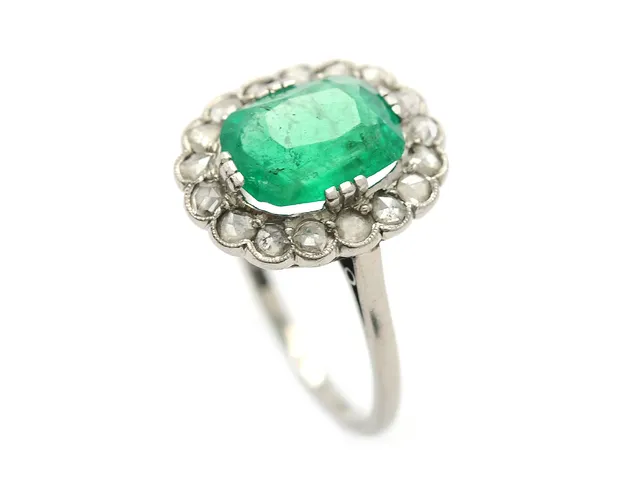 CARMOSÉRING, 18K vitguld, ovalt fasetterad smaragd ca 2,80 ct, inneslutningar når ytan, nagg, 17 rosenstenar ca 0,50 ctv, Thomasson, Stockholm 1936, stl 18,25 mm, vikt 4,9 g, 5 diamanter är skadade, etui.