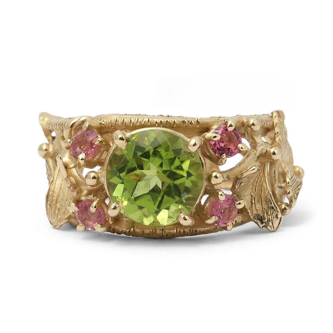 A peridote and tourmaline ring set with a circular-cut peridote and four circular-cut pink tourmalines, mounted in 14k gold. Weight app. 6.4 g. Size 53.5. — Jewellery/Rings — Bruun Rasmussen