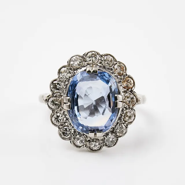 RING, platina, 1 ovalslipad safir, ca 2,50-2,75 ct, krans med 16 gammalslipade diamanter, totalt ca 0,56 ct, otydlig mästarstämpel, Stockholm 1934.
