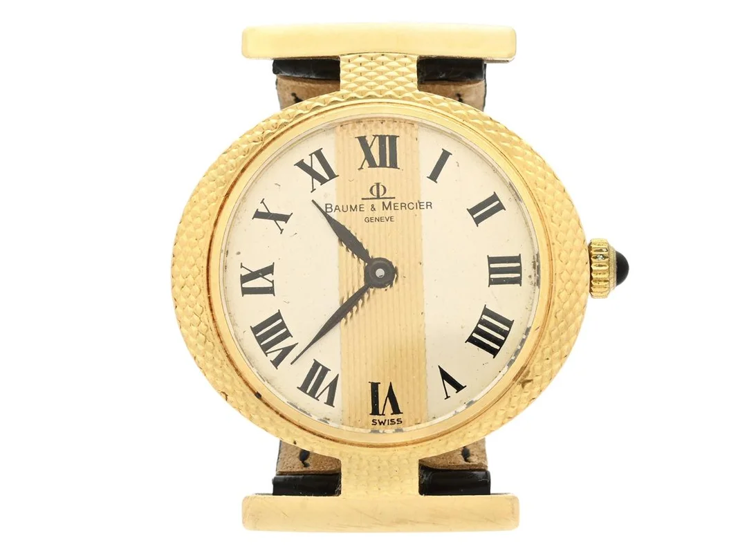 BAUME & MERCIER, Geneve, damur, 27 mm, Cal BM 777, Boett nr. 04 / 798714 / 36618 / 421, 18K guld, manuell, safirglas (repor/nagg), skadad urtavla, integrerat läderband, originalspänne i doublé (10 micron), ca 1975. — Klockor/Baume&Mer — Kaplans