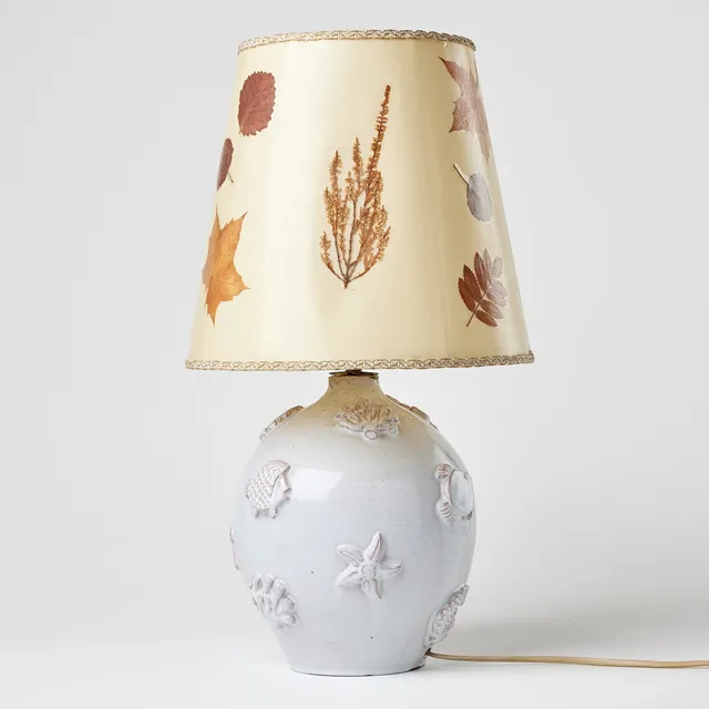 LISBET JOBS. Bordslampa, egen verkstad 1938, lergods med reliefdekor av sjöväxter och fiskar, vit glasyr.