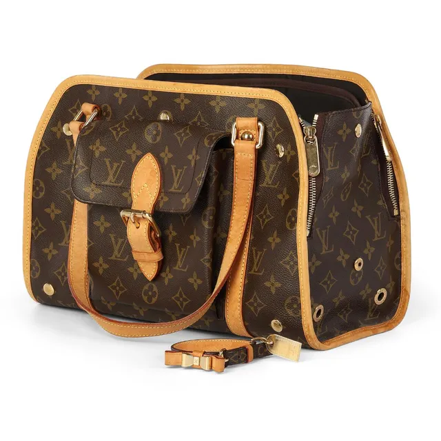 A “Baxter GM” dog carrier bag of brown monogram canvas with brown leather trimmings, gold tone hardware, two handles, an exterior front pocket, one compartment with two side pockets and dark brown lining. Accompanied by dog collar. Bag H. 24 x W. 34 x D. 16 cm. Collar L. app. 20–25 cm. 2007. (2)