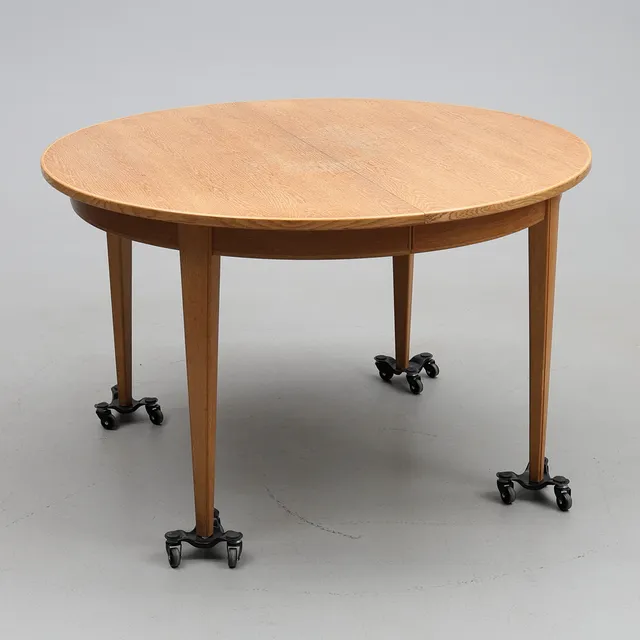 GUNNI OMANN. Cirkulärt matbord i ek med utdragbara, avsmalnande ben, med 3 iläggsskivor . Tillverkad på Omann Jun's Møbelfabrik, Danmark, modell '55'.