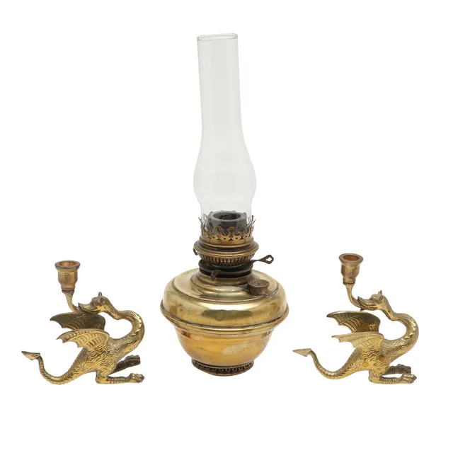 A PAIR OF BRASS DRAGON CANDLESTICKS AND A BRASS OIL LAMP BASE.