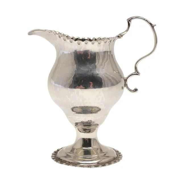 A GEORGE III SILVER CREAM JUG.