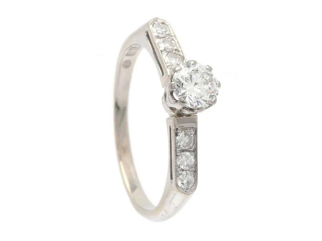 RING, 18K vitguld, briljantslipad diamant 0,46 ct enligt gravyr, ca W/VS, 6 åttkantslipade diamanter 0,18 ctv, ca TW/VS, stl 17,5 mm, vikt 3,0 g, mittstenen med inneslutning som når ytan, nagg på kulett samt natural på rondisten. — Smycken/Ring — Kaplans