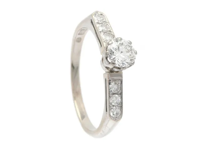 RING, 18K vitguld, briljantslipad diamant 0,46 ct enligt gravyr, ca W/VS, 6 åttkantslipade diamanter 0,18 ctv, ca TW/VS, stl 17,5 mm, vikt 3,0 g, mittstenen med inneslutning som når ytan, nagg på kulett samt natural på rondisten.