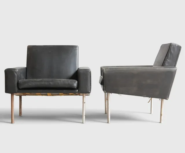 HANS J WEGNER. “Lufthavnsstolen”, et par lænestole med ben af stål, betrukket med sort kunstskind, løse sædehynder. Udført hos AP-stolen, model AP-34U. Danmark, 1960-70'erne (2).
