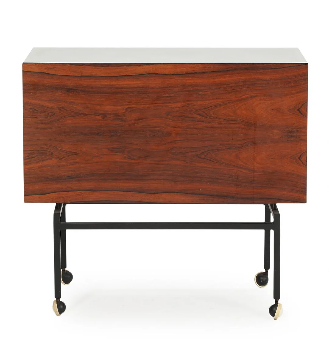 A rosewood bar cart, sliding top with white formica. Inside with two large storage compartments. Mounted on black lacquered steel frame with castors. 1960–70s. H. 77. L. 84. W. 42 cm. — Modern Furniture — Bruun Rasmussen