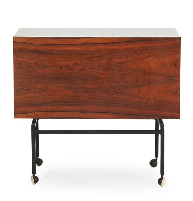 A rosewood bar cart, sliding top with white formica. Inside with two large storage compartments. Mounted on black lacquered steel frame with castors. 1960–70s. H. 77. L. 84. W. 42 cm.