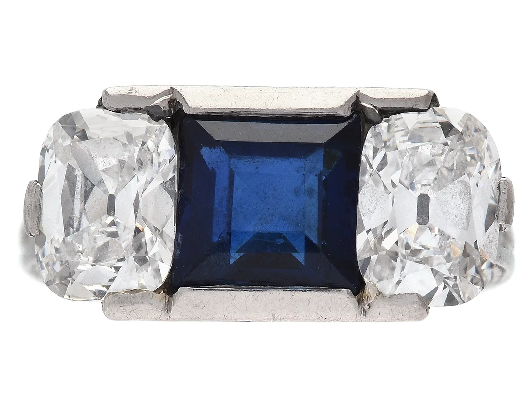 RING, platina, 2 kuddslipade diamanter ca 1,90 ctv, ca W(H)/VVS2, safir ca 1,50 ct, skadade kanter, 8 äldre åttkantslipade diamanter ca 0,18 ctv, 14 små safirer, stl 16,25 mm, vikt 4,0 g, tolv safirer saknas i det undre galleriet som behöver repareras, — Smycken/Ring — Kaplans