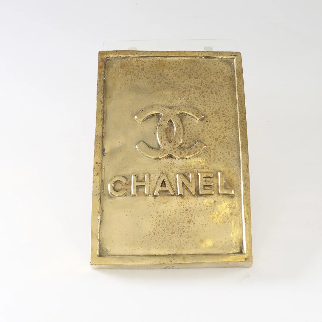 ANDREAS WARGENBRANT. f 1967, Skylt "Chanel", hommage, guldpatinerad brons. — Sculptures & Bronzes — Auktionsverket Engelholm