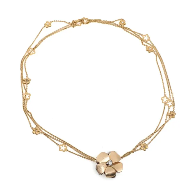 Flower clasp in 14k gold and white gold set with two brilliant-cut diamonds accompanied by flower chain in 18k gold. Claps diam. 2.5 cm. Chain L. 42 cm. Weight app. 27 g. Lilac cotton cord with sterling silver ends. (3)