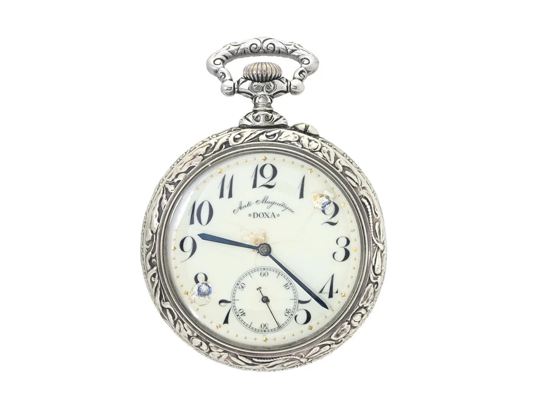 DOXA, Anti-Magnetique, fickur, 69,5 mm, Boett nr. 700574, vitmetall, ankargång, skadad / renoverad urtavla, motiv (Lok), ca 1910. — Klockor/Doxa — Kaplans