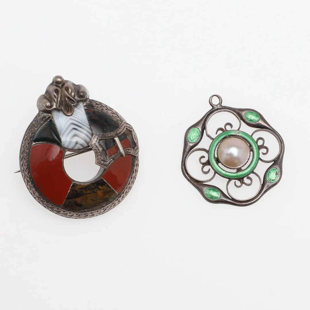 AN ART NOUVEAU SILVER AND ENAMEL PENDANT AND A VICTORIAN SCOTTISH SILVER PEBBLE BROOCH. — Brooches & Pendants — Lawrences Auctioneers