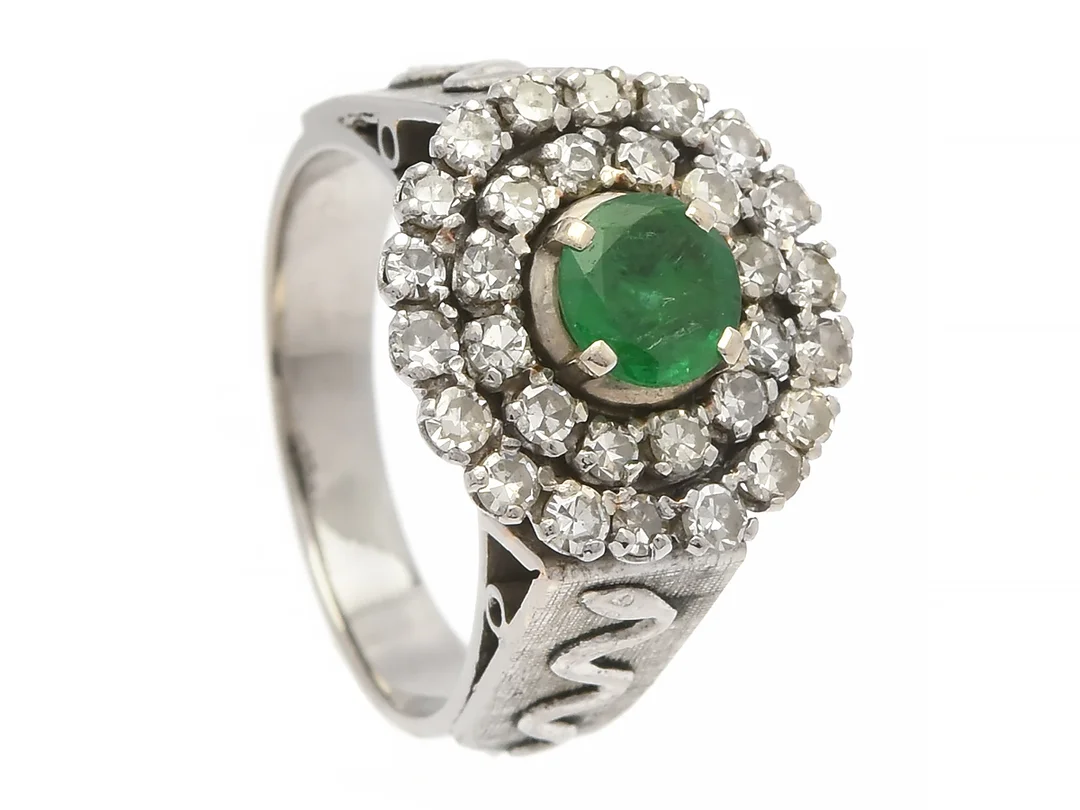 RING, låghaltigt vitguld, smaragd ca 0,50 ct, 30 åttkantslipade diamanter ca 0,66 ctv, ca W-TCa(H-K)/VS-SI, stl 16,5 mm, vikt 7,7 g, smaragd med nagg och mindre skador, hög palladiumhalt i guldet. — Smycken/Ring — Kaplans