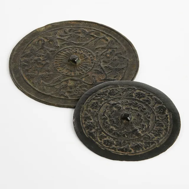 BRONSSPEGLAR, 2 st., Kina, Tang-stil, möjligen Ming (1368-1644), träställ medföljer.