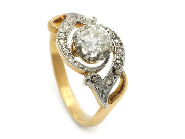 RING, 18K guld/platina, antikslipad diamant ca 0,56 ct, ca TCr(I)/VS, rosenstenar, en rosensten saknas, några skadade, stl 16,75 mm, vikt 4,4 g.