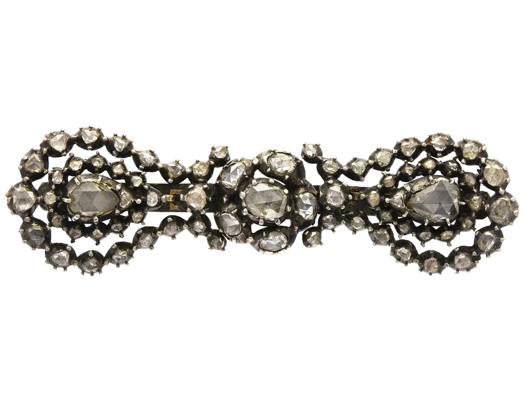BROSCH, silver/14K guld, rosenslipade diamanter ca 1,50 ctv, ca W-Ca/SI-P, längd 7 cm, vikt 14,3 g, flertalet diamanter med nagg och mindre skador. — Smycken/Brosch — Kaplans