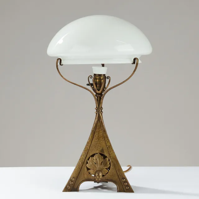 JUGENDSTIL: Skulpturel bordlampe af hammerslået messing dekoreret med relieffer af grankogler og blade, europæisk lampeproducent, 1900-tallets begyndelse.