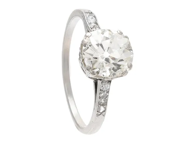 RING, platina, gammalslipad diamant ca 2,50 ct, ca Cr(J)/skador och nagg på rondisten/paviljongen samt tunn rondist, i övrigt små inneslutningar, briljant- och åttkantslipade diamanter ca 0,12 ctv, stl 17,5 mm, vikt 3,2 g, två små diamanter är utbytta mot vita stenar, smådiamanter med skador, ringskena med skador och svaga fattningar.