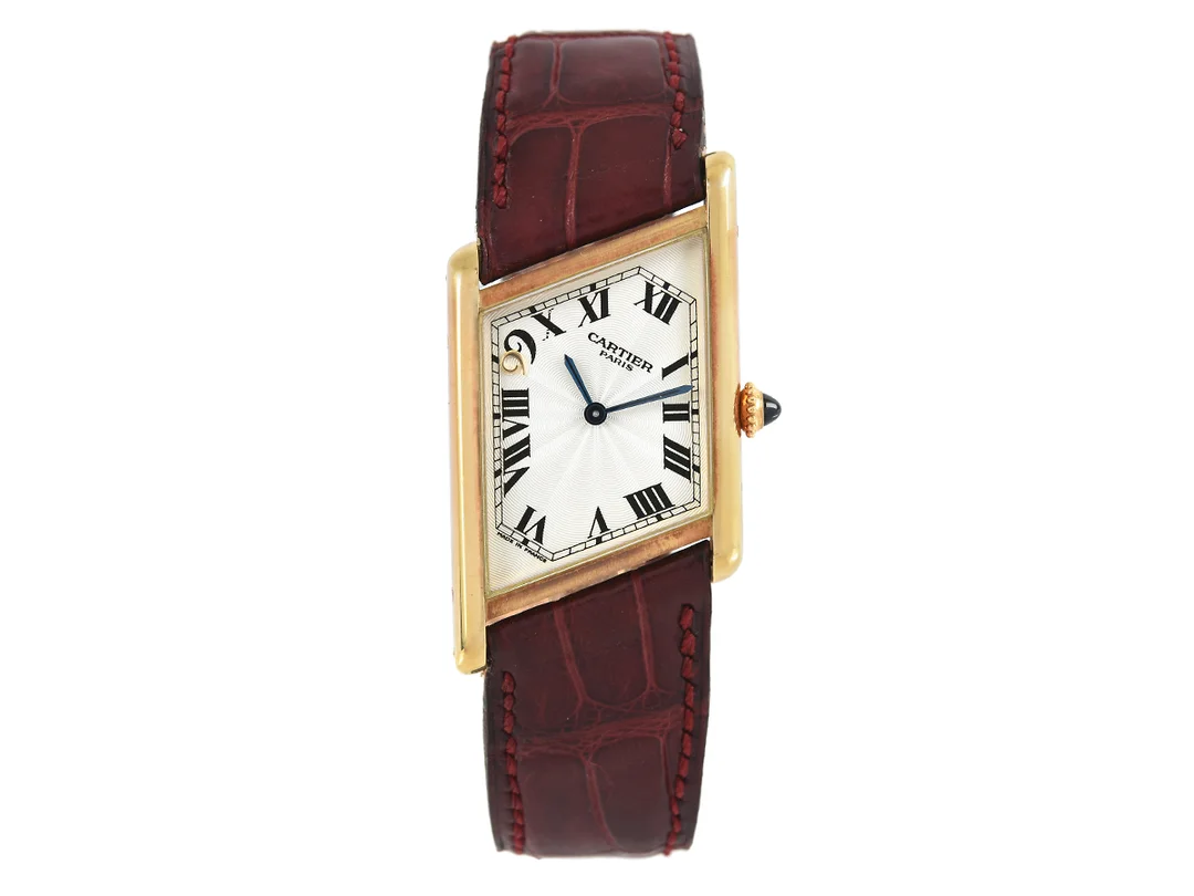 CARTIER, Tank, Macau - 1999, "Asymmetric", Cal 9P2, Verk nr. 9407157, Boett nr. 2488, unisex, 23 x 26 (34) mm, 18K guld, manuell, safirglas, glasbaksida, läderband, viklås i 18K guld, ca 1999, box (skadad), ytterkartong. Limiterad och numrerad (Nr. 74/99). — Klockor/Cartier — Kaplans