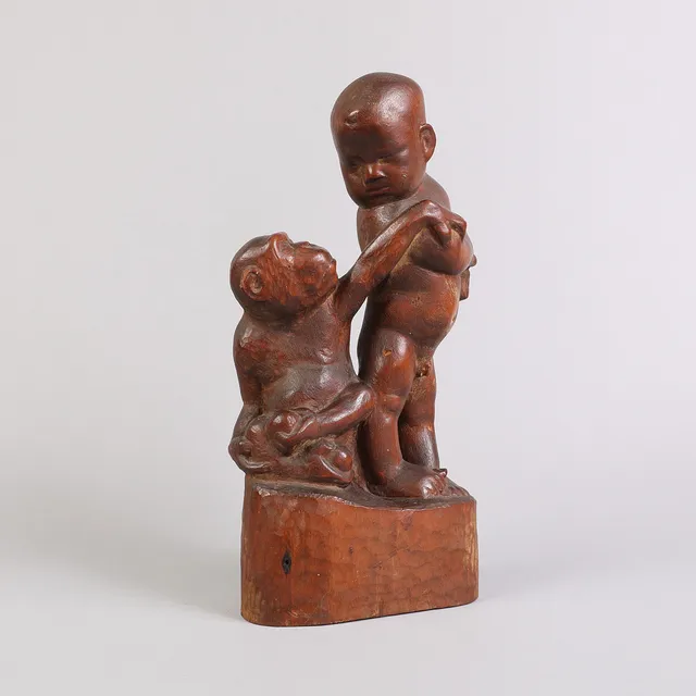 ALOYS MAYER (1855-1936). Skulptur af udskåret og patineret træ i form af dreng og abe med frugter, 1921.