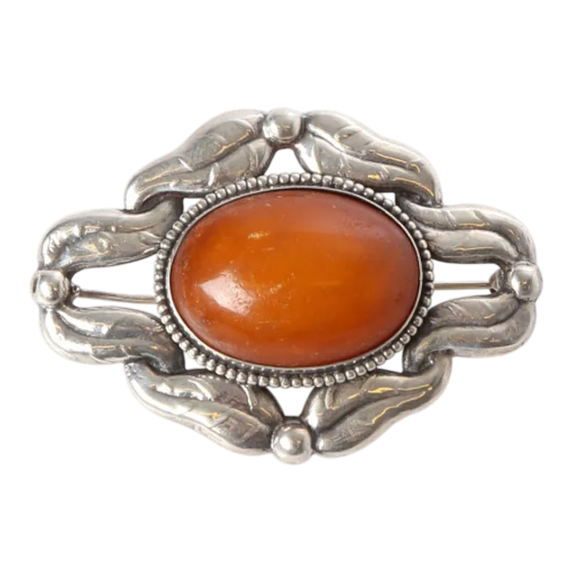 BERNHARD HERTZ. Skønvirke broche af sølv og rav, ca. 1915.