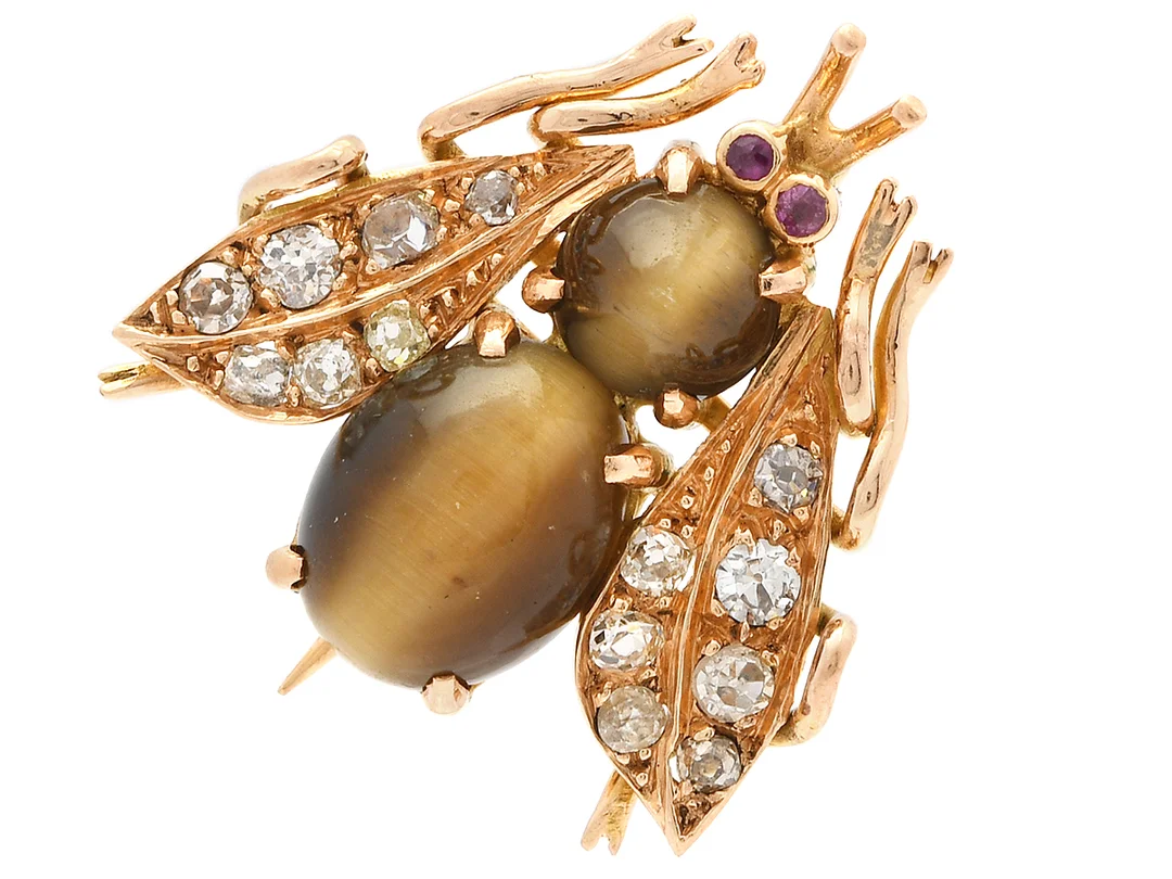 BROSCH, insekt, 18K guld, cabochonslipad tigeröga, rubiner, antik- och gammalslipade diamanter, mått 22x22 mm, vikt 5,4 g, några diamanter har nagg och skador. — Smycken/Brosch — Kaplans