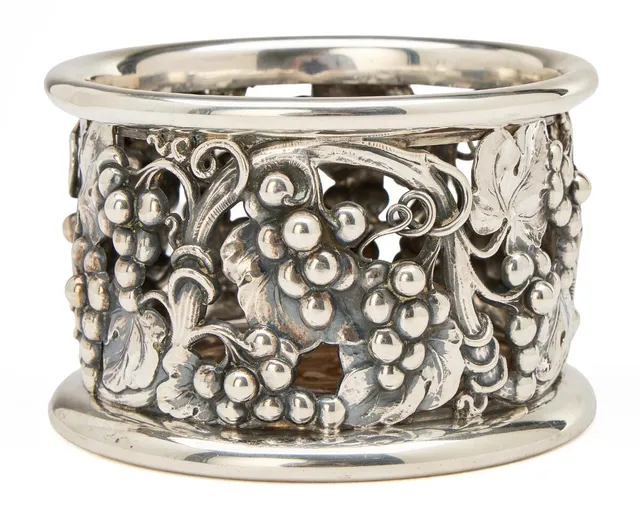 Sterling silver bottle coaster, pierced motifs with vines and grapes. Fitted with a loose carved mahogany base. Made by Evald Nielsen, Denmark. Weight 326 g. H. 7.4 cm. Diam. 11.5 cm.