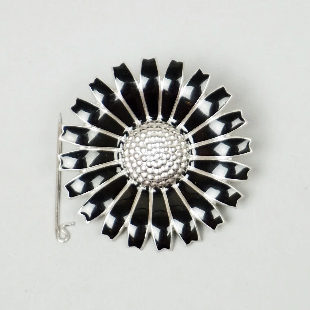 GEORG JENSEN, "Daisy", hänge (omgjord brosch), sterlingsilver med emaljdekor, Danmark. — Jewellery — Roslagens Auktionsverk