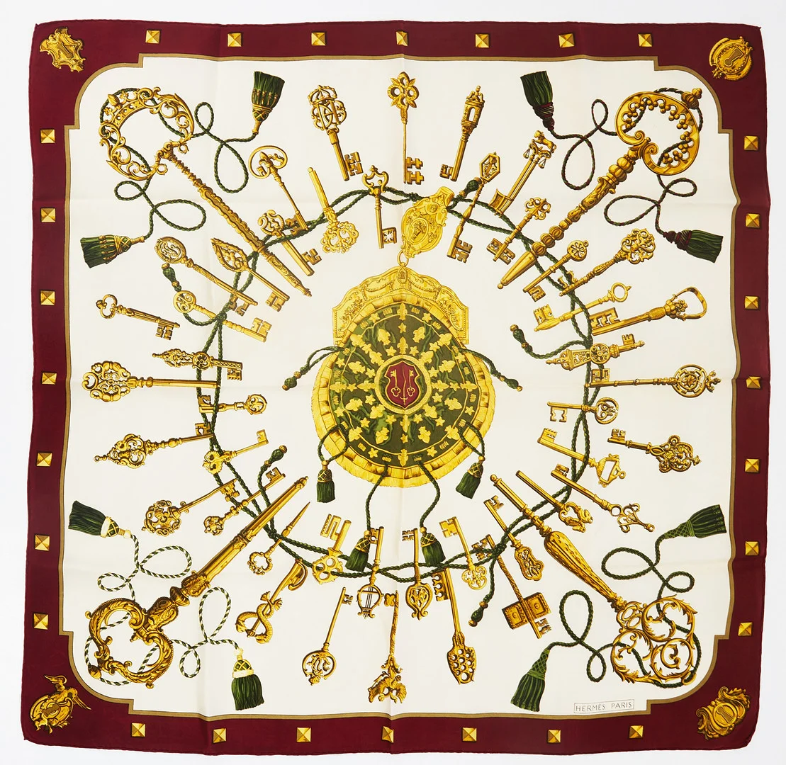 HERMÈS, "Les Clefs", scarf, siden, designad av Cathy Latham för Hermès 1965, motiv av nycklar på crèmevit botten, vinröd bård. — Vintage & Designer Fashion — Stockholms Auktionsverk Magasin 5