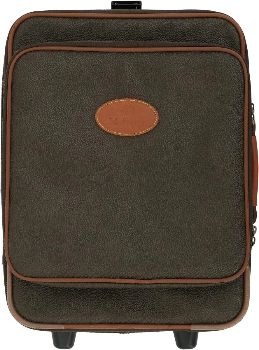 A “Heritage” trolley of brown Scotchgrain leather with brown leather trim, a top handle, an extendable handle, an exterior zippered compartment with two interior pockets, and a central exterior zippered compartment with an interior zippered pocket, as well as a buckle strap and checked microfiber lining. H. 50 × W. 42 × D. 22 cm. — Designer Handbags & Fashion/Designer Handbags — Bruun Rasmussen