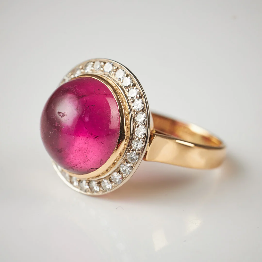 RING, 18 k guld, cabochonslipad rosa turmalin bekransad av 27 åttkantslipade diamanter, total ca 0,27 ct, Guldsmed Rune Thorell, Stockholm 1978. — Rings — Stockholms Auktionsverk Magasin 5