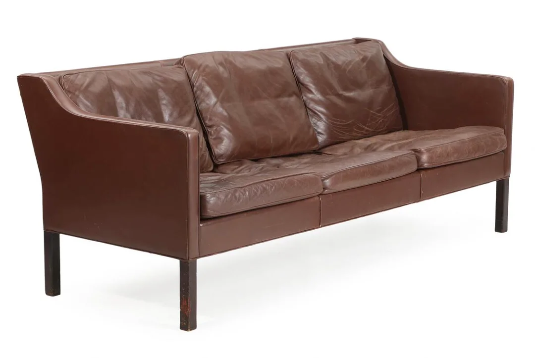 Freestanding three-seater sofa with dark-stained oak legs. Seat, sides and back upholstered with brown leather. Model 2423. Designed in 1963. Manufactured by Fredericia Stolefabrik. L. 188 cm. — Modern Furniture — Bruun Rasmussen