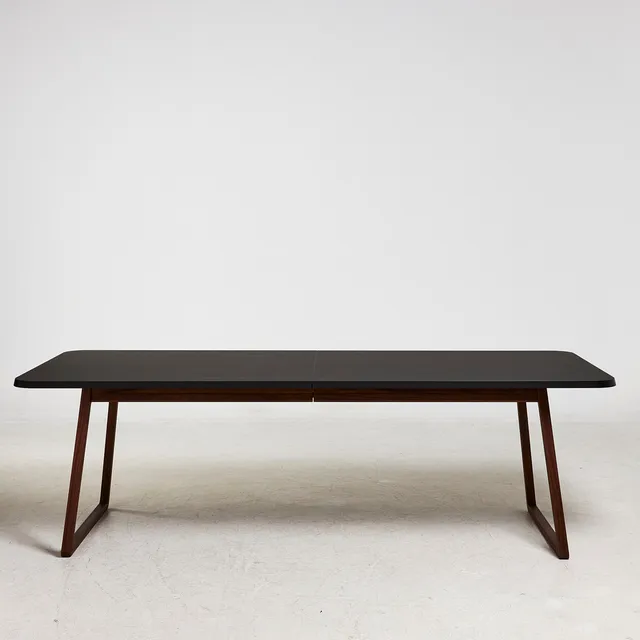 NISSEN & GEHL (GM DESIGN). Matbord, "GM 3640 Nano Bord", för Naver Collection, skiva i svart laminat, benställning i oljad valnöt, samtida.