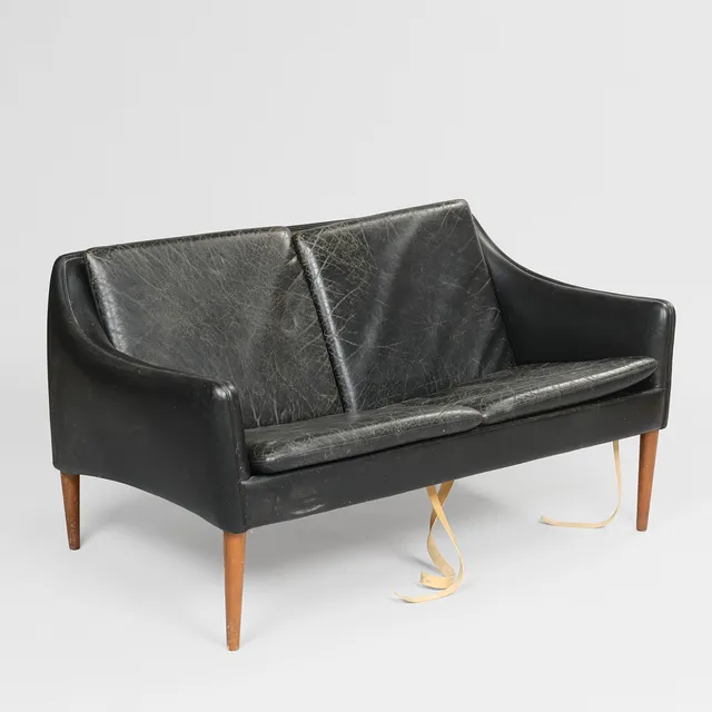 HANS OLSEN (1919-1992). To-personers sofa betrukket i sort læder med ben af massivt teaktræ, C/S Møbler, model 800/2, Danmark, 1950'erne.