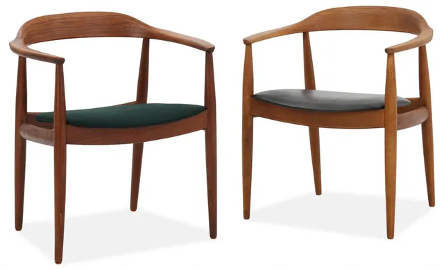 A pair of stained elm armchairs, seat upholstered with black leather and wool. Made and marked by Eilersen. (2)