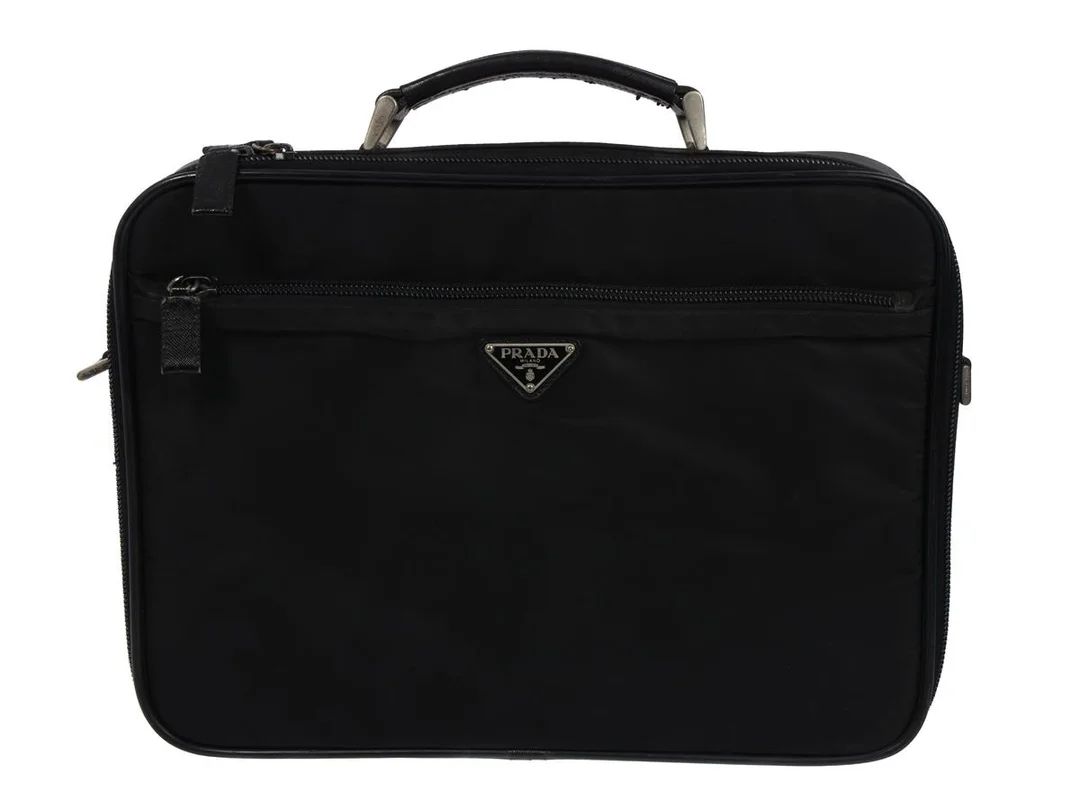 VÄSKA, PRADA, portfölj, svart nylon canvas, silverfärgade beslag, 38x28x8 cm, handtag i svart läder, bruksslitage. — Accessoarer/Väskor — Kaplans